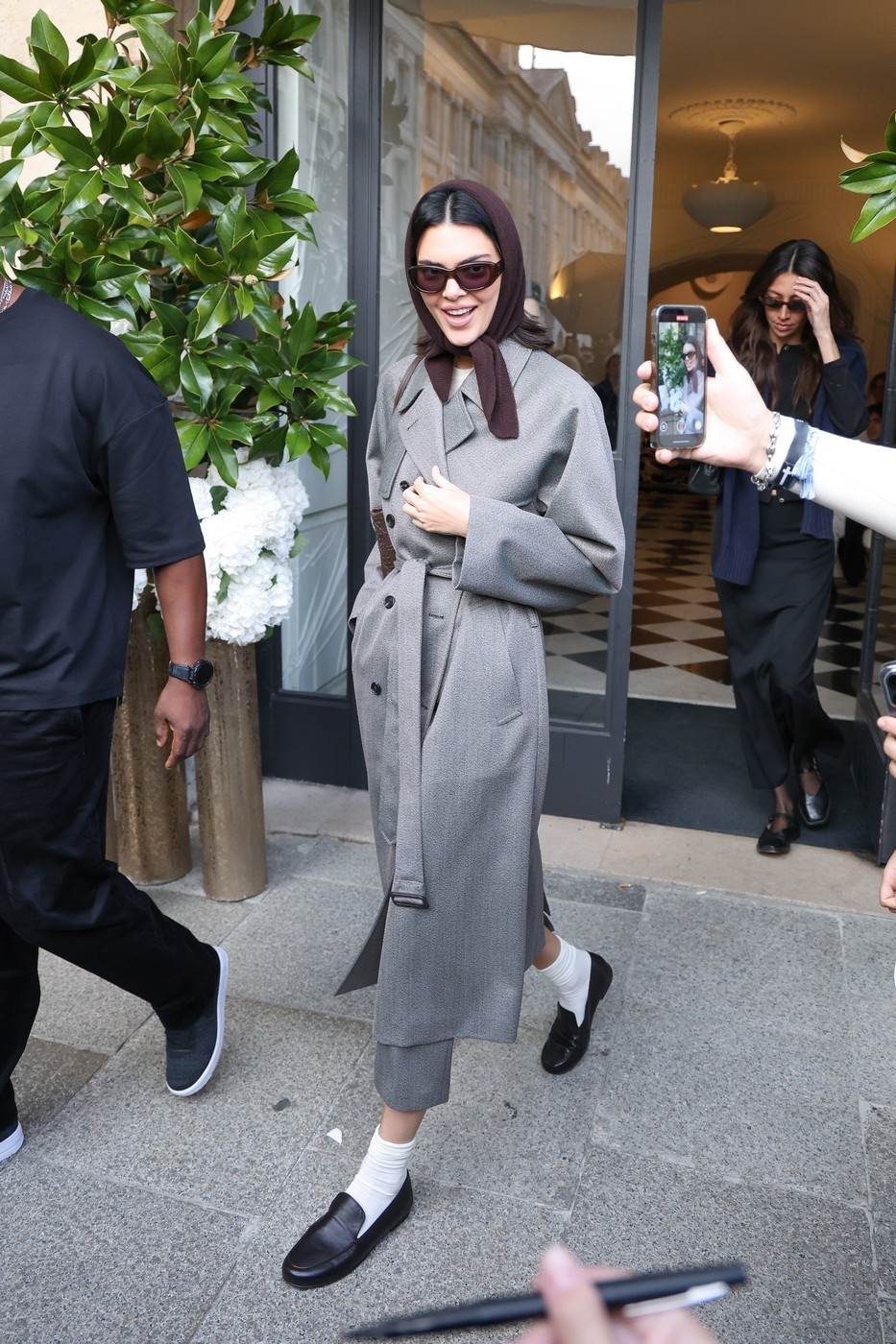 Kendall Jenner izlazi iz prodavnice u sivom kaputu dok je fanovi fotografišu