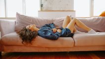 devojka leži na kauču