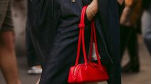 Žena nosi crvenu torbu.
