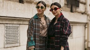 Dve devojke u kariranim trench mantilima.