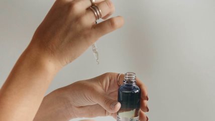 Krupan kadar ruku koje drže bočicu u kojoj je tečnost