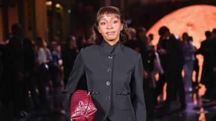 Glumica Ayo Edebiri  na Chanel reviji 2025. u Parizu sa bordo torbom.