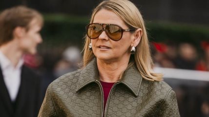 Žena u kratkoj khaki kožnoj jakni i tamnim farmerkama.