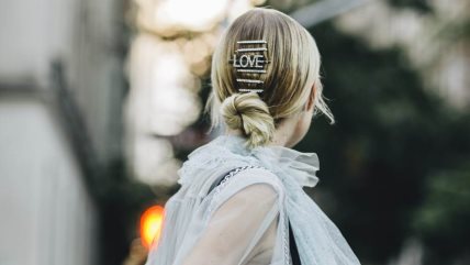 Žena u providnoj bluzi u viktorijanskom stilu sa LOVE ukosnicom u kosi.