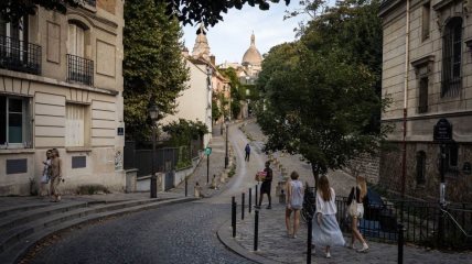 Ljudi šetaju u Parizu ulicama Montmartrea idu prema Sacre-Coeur Basilica.