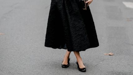 Žena u crnoj suknji i baletankama u istoj nijansi.