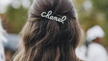 Brineta sa talasastom frizurom i Chanel šnalom ta kosu.