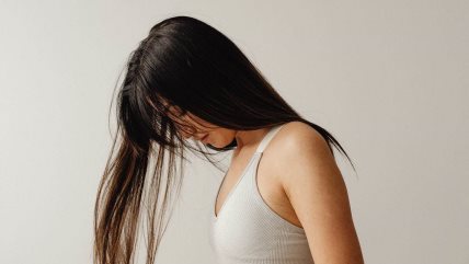 Krupan kadar žene sa dugačkom tamnom kosom koja je puštena preko njenog lica.