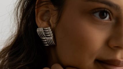 Krupan kadar na lice žene sa tamnom kosom i upečatljivom srebrnom minđušom.