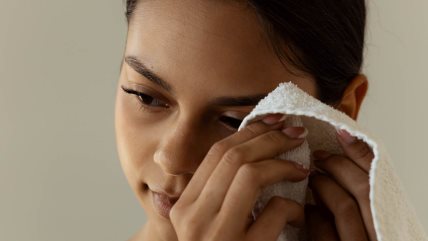 Krupan kadar žene koja belim peškirom briše lice.