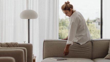 Žena sedi na bež dvosedu.