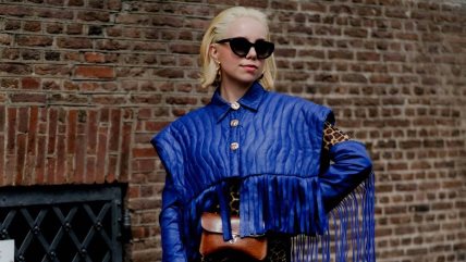 Žena sa kratkom svetlom kosom u plavoj jakni.