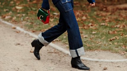 Žena u tamnim farmerkama i kožnim crnim čizmama sa špicastim vrhom.