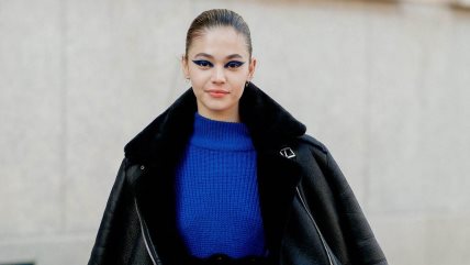 Devojka u plavoj pletenoj haljini i crnom krznenom kaputu.