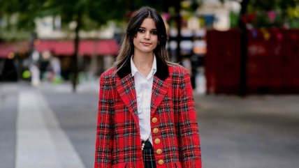 Žena u beloj košulji i crvenom kariranom sakou.