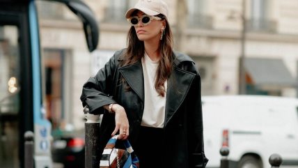 Devojka u beloj majici, crnim helnkama i kožnoj jakni.