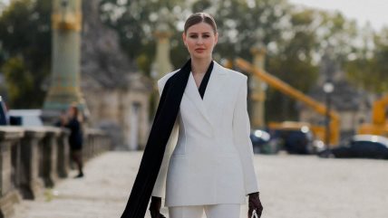 Žena u belom odelu i sa crnim šalom.