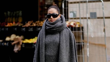 Devojka u sivom džemperu sa oversized šalom u istoj nijansi.