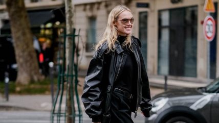 Žena u crnoj rolci, kožnoj jakni i pantalonama u istoj nijansi.