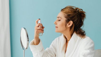 Žena nanosi fiksator na lice.