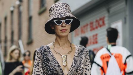 Žena sa u haljini sa animal printom, i sa kapom u istom dezenu.