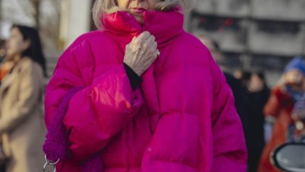 Žena u dugačkoj roze puffer jakni.