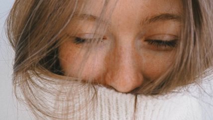 Krupan kadar na lice devojke u bejol rolci.