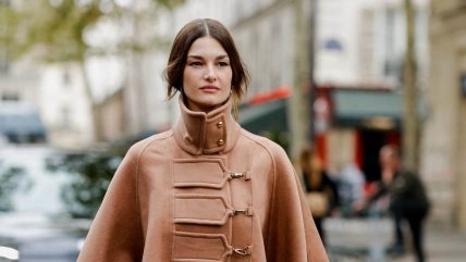 Žena u braon kaputu sa visokom kragnom.