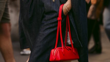 Žena nosi crvenu torbu.
