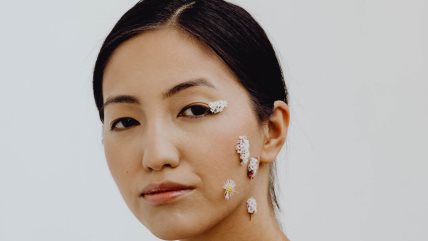 Krupan kadar žene koja na licu ima cvetove.