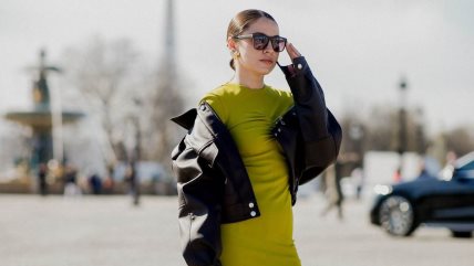 Devojka u zelenoj haljini i kožnoj jakni.