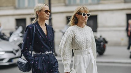 Dve žene - jedna u total teget kombinaciji druga u skroz beloj - šetaju ulicom.