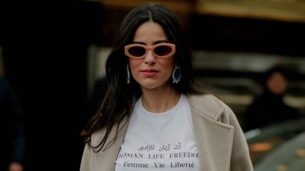 Žena u beloj majici sa natpisom.