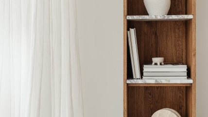 Polica sa knjigama i keramičkim figurama.