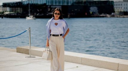 Žena u krem pantalonama i beloj majici.