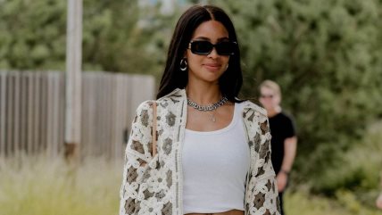 Devojka u beloj bluzi i sivim farmerkama.