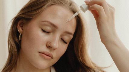 Krupan kadar na ženu koja nanosi serum na lice.