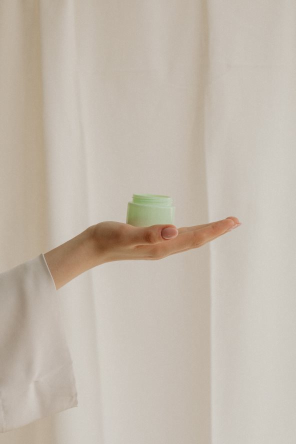 Krupan kadar na ruku žene koja drži kremu.