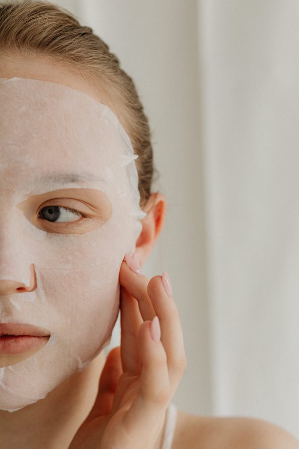 Krupan kadare žene koja ima sheet masku za lice.