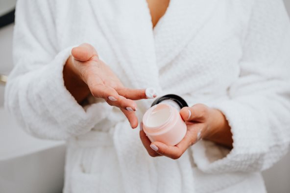 Krupan kadar na ruke žene koja nanosi kremu.