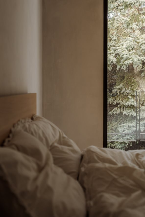 Krevet u sobi sa velikim prozorom.